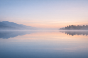 Still lake at dawn symbolising silence, quietude, and inner peace